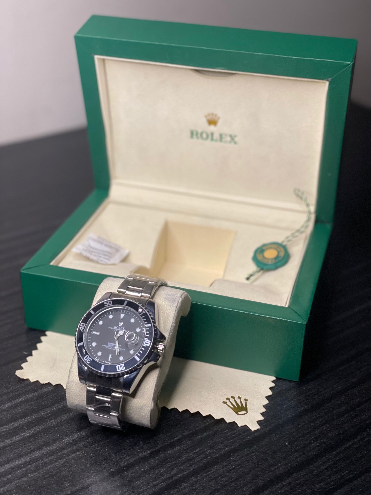 Rolex watch in a green box on a dark surface
