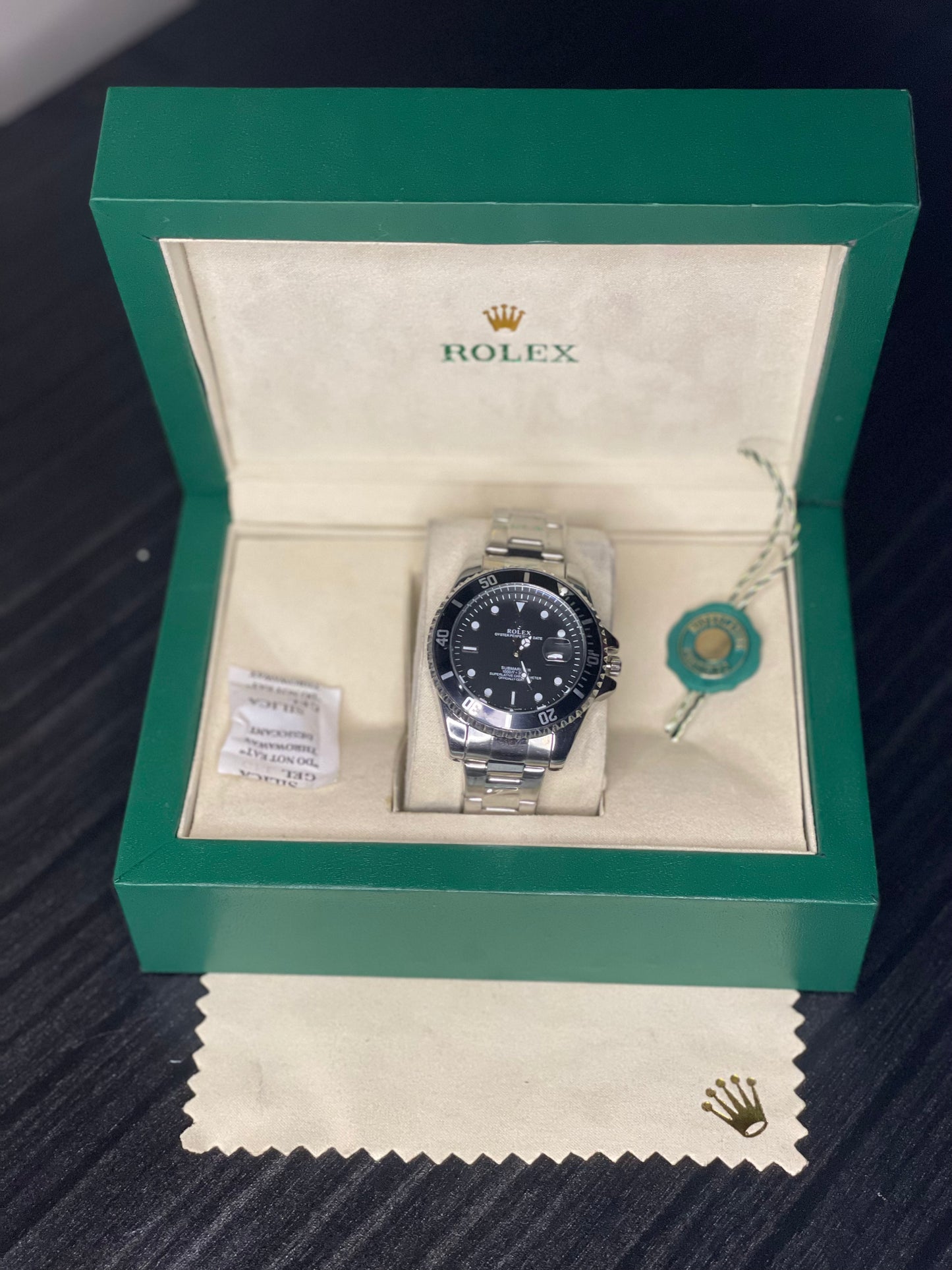 Rolex watch in a green box on a dark surface