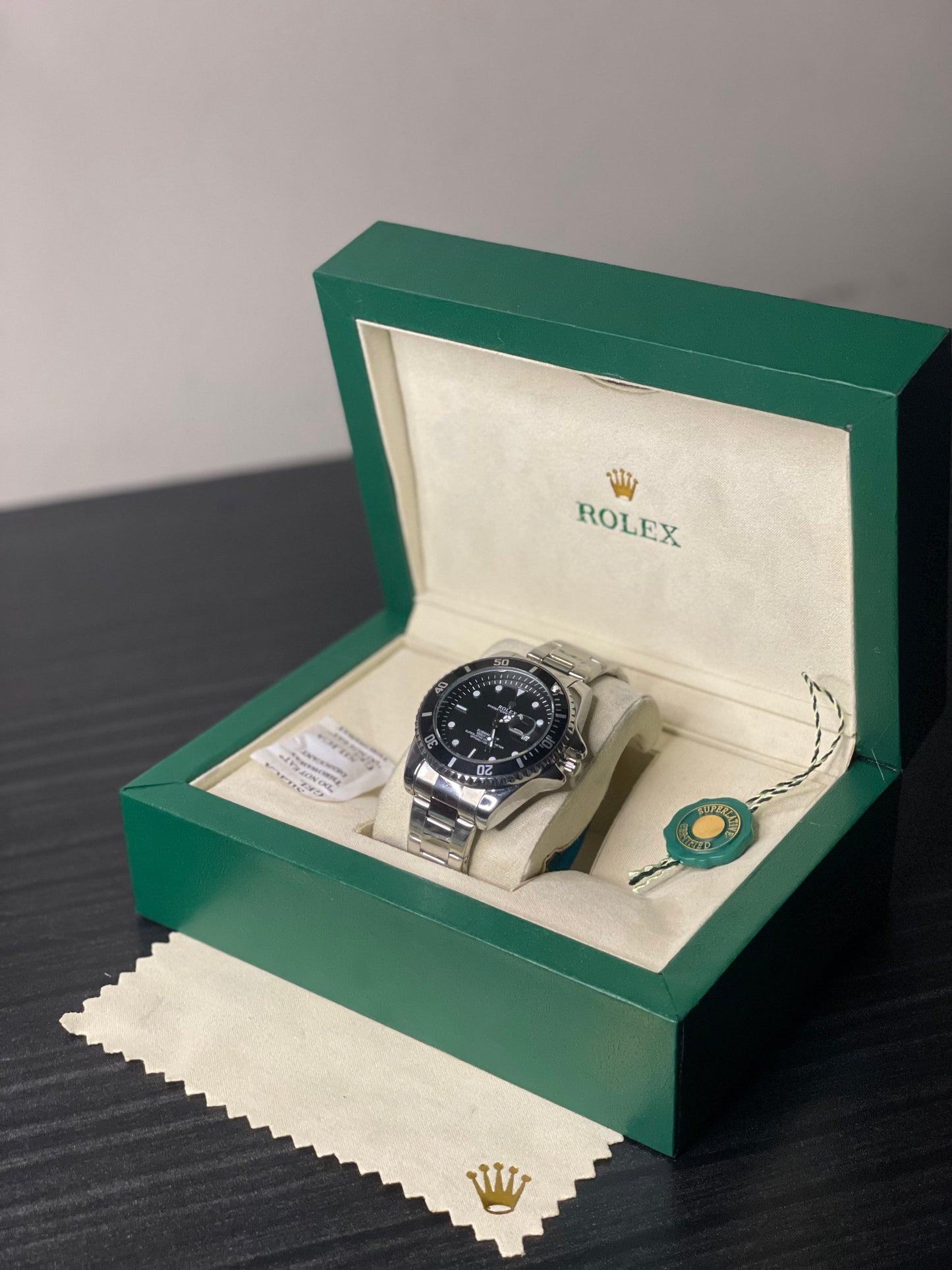Rolex watch in a green box on a dark surface