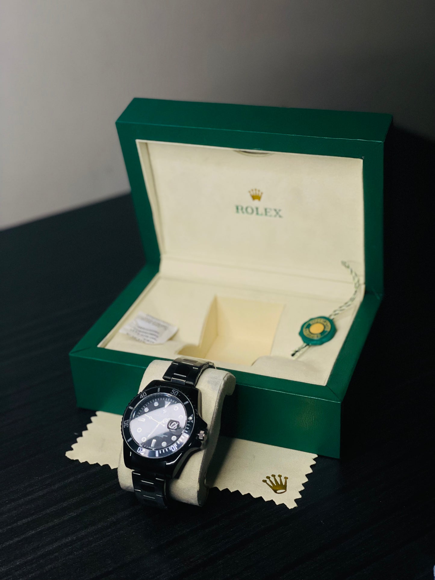 Rolex watch in a green box on a dark surface