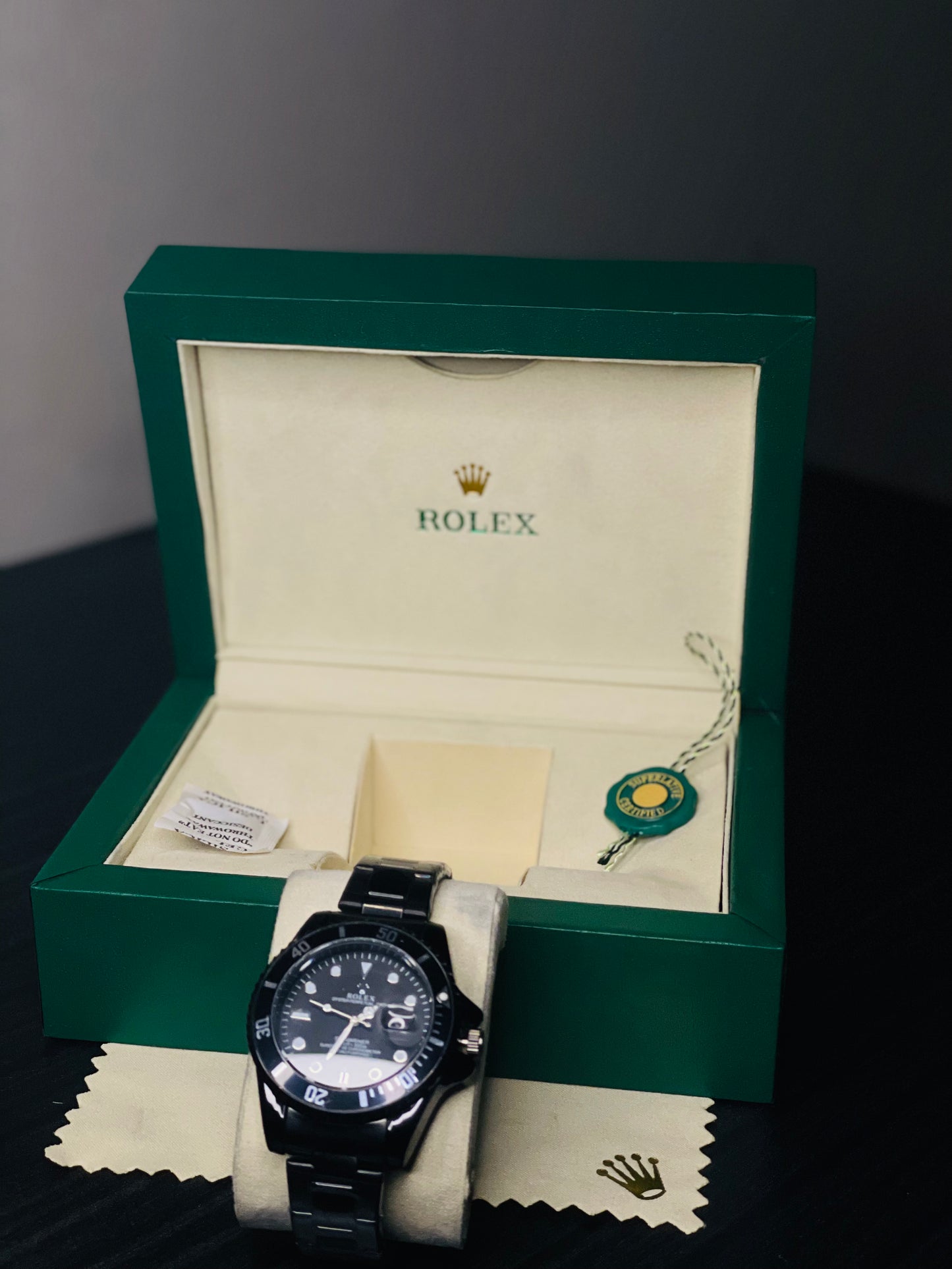 Rolex watch in a green box on a dark surface