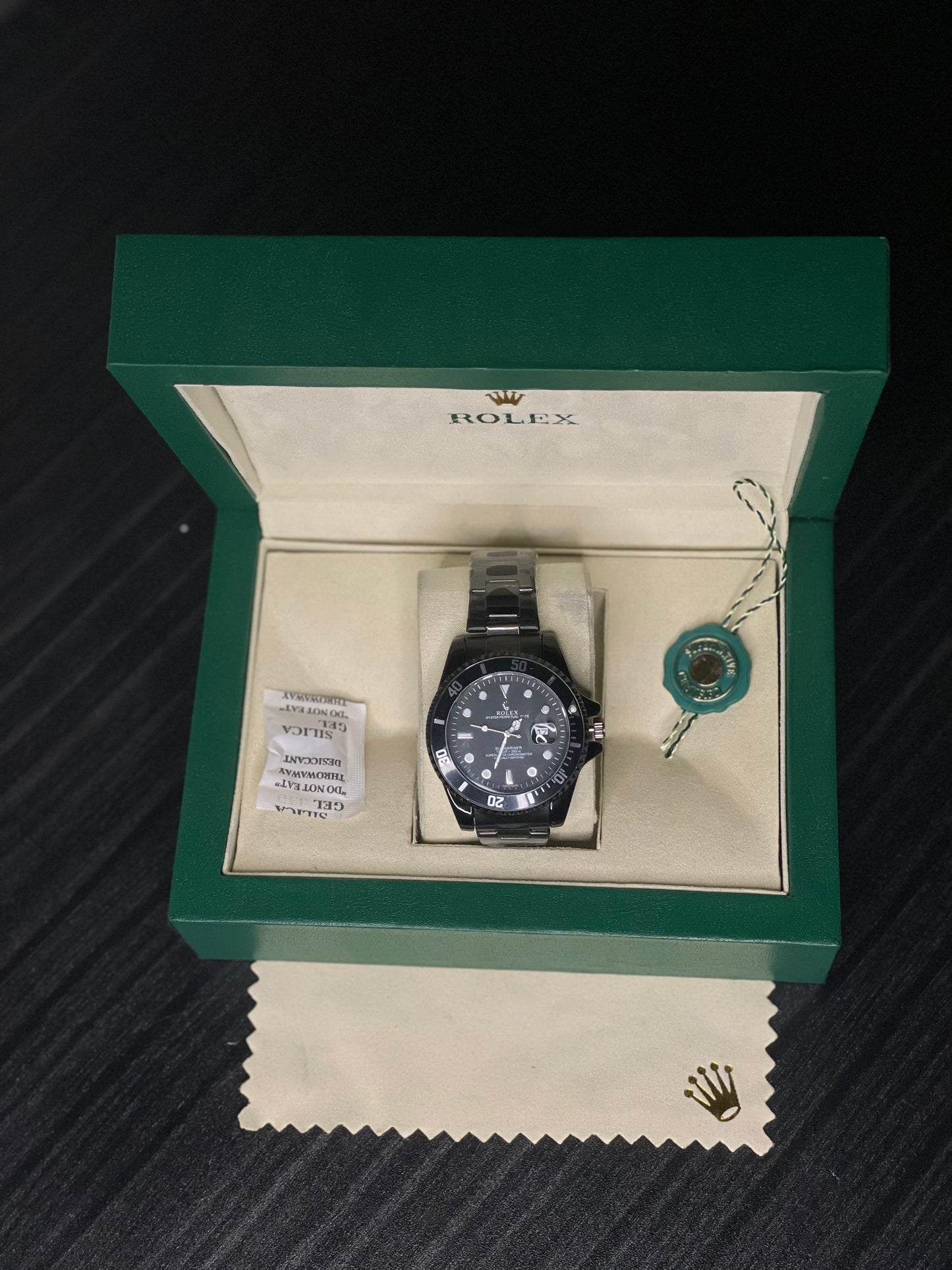 Rolex watch in a green box on a dark surface