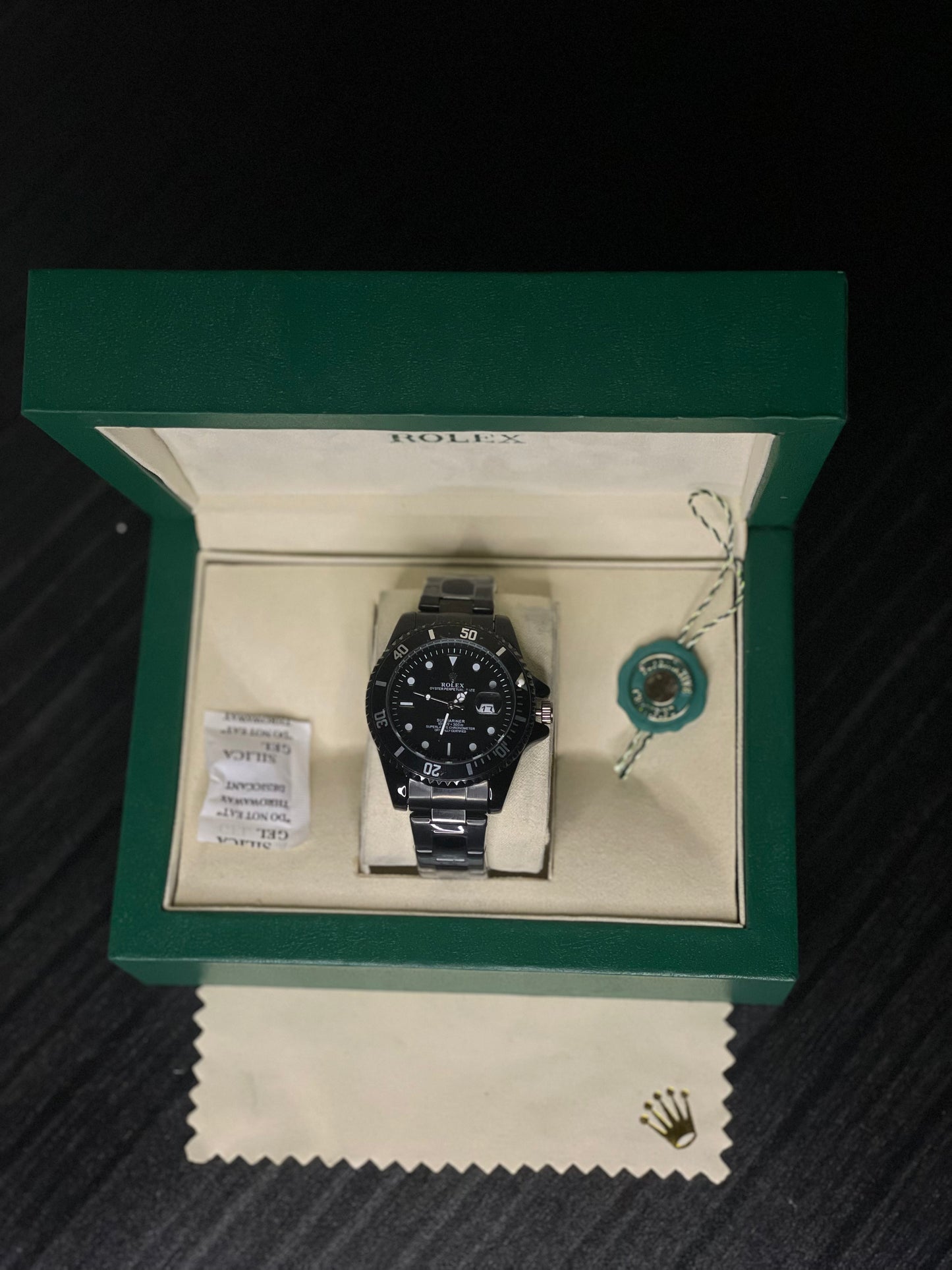 Rolex watch in a green box on a dark surface